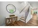 Inviting entryway with wood floors, a staircase, and a decorative table with a round mirror at 420 Balboa St, Matthews, NC 28104