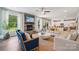 Bright living room with a stone fireplace, hardwood floors, and large windows showcasing the outdoor view at 420 Balboa St, Matthews, NC 28104