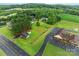 Aerial view of brick home near wooded area and commercial property with parking at 522 Ne Connector Hwy, Albemarle, NC 28001