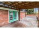 Inviting covered back deck with wooden floors, brick exterior, and view of the yard and trees at 522 Ne Connector Hwy, Albemarle, NC 28001