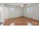 This bedroom has wood floors, a ceiling fan, and two windows at 522 Ne Connector Hwy, Albemarle, NC 28001