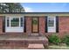 Charming brick home entrance with a decorative wreath, welcome mat, and window shutters at 522 Ne Connector Hwy, Albemarle, NC 28001