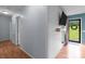 Hallway featuring hardwood floors, leading to a doorway with a view of the outdoors and shiplap accent wall at 522 Ne Connector Hwy, Albemarle, NC 28001