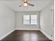 Empty bedroom with hardwood floors, ceiling fan, and a window providing lots of natural light at 6401 Montpelier Rd, Charlotte, NC 28210