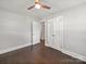 Bedroom with dark hardwood floors, large closet, ceiling fan, and neutral paint at 6401 Montpelier Rd, Charlotte, NC 28210