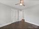 Vacant bedroom with hardwood floors, ceiling fan, and a double door closet for ample storage at 6401 Montpelier Rd, Charlotte, NC 28210
