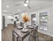 A bright dining area has a modern ceiling fan, sliding glass doors to the deck, and a view into the kitchen at 6401 Montpelier Rd, Charlotte, NC 28210