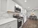 Kitchen with stainless appliances, white cabinetry, and dining area with wall accent and modern decor at 6401 Montpelier Rd, Charlotte, NC 28210