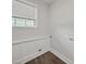Bright laundry room features hardwood floors, wainscoting, and a window for natural light at 6401 Montpelier Rd, Charlotte, NC 28210