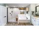 Bathroom featuring a tiled shower, soaking tub, and modern vanity with black hardware at 7030 Butternut Oak Ter, Huntersville, NC 28078