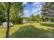 Wide shot of grassy backyard with some trees and bushes around the edge of the property at 7785 Crestwood Dr, Kannapolis, NC 28081
