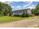 Single-story home with a charming front porch and landscaped yard with a large grassy area at 7785 Crestwood Dr, Kannapolis, NC 28081