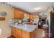 View of the kitchen with wood cabinets, white countertops and a view of the living area at 7785 Crestwood Dr, Kannapolis, NC 28081