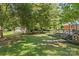 Spacious backyard featuring a wooden deck, mature trees, and manicured lawn at 8101 Truelight Church Rd, Mint Hill, NC 28227