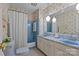 Floral bathroom featuring a double vanity, a tub with shower, and vintage-style fixtures at 8101 Truelight Church Rd, Mint Hill, NC 28227