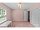 Bright bedroom with a large window, pink walls and carpet, and a table at 8101 Truelight Church Rd, Mint Hill, NC 28227