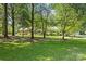 Charming brick home nestled among mature trees, with a well-manicured front lawn at 8101 Truelight Church Rd, Mint Hill, NC 28227
