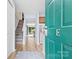 Entryway with wood staircase, floors, and green front door leading to the kitchen and living spaces at 9606 Vinca Cir # E, Charlotte, NC 28213