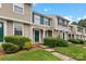 Neat townhome row displaying manicured lawns, lush shrubbery, and uniform green door accents at 9606 Vinca Cir # E, Charlotte, NC 28213