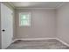 Bedroom with gray vinyl flooring, light gray walls, gray trim, and one window at 9763 Pine Tree Ln, Norwood, NC 28128