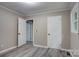 Bedroom with gray vinyl flooring, light gray walls, gray trim plus two doors at 9763 Pine Tree Ln, Norwood, NC 28128
