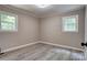 Bedroom with gray vinyl flooring, light gray walls, gray trim and two white doors at 9763 Pine Tree Ln, Norwood, NC 28128