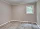 Bedroom with gray vinyl flooring, light gray walls, gray trim, and one window at 9763 Pine Tree Ln, Norwood, NC 28128