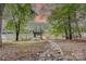 Scenic waterfront property showcasing a wooden dock extending into a tranquil lake surrounded by lush trees at 9763 Pine Tree Ln, Norwood, NC 28128