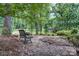Serene garden scene featuring a decorative wrought iron bench in a peaceful, wooded setting at 9763 Pine Tree Ln, Norwood, NC 28128