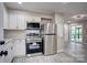 Modern kitchen features white cabinets, stainless steel appliances, and contemporary flooring at 9763 Pine Tree Ln, Norwood, NC 28128
