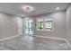 This living room has gray walls and flooring plus a door to the porch with a view of the water at 9763 Pine Tree Ln, Norwood, NC 28128