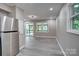 A living room with gray walls and flooring includes access to a porch and a view of the outdoors at 9763 Pine Tree Ln, Norwood, NC 28128