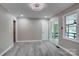 This living room features gray walls and floors plus a door to the porch with a view of the lake at 9763 Pine Tree Ln, Norwood, NC 28128