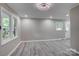 This spacious living room has gray walls, gray flooring and plenty of light from the large windows at 9763 Pine Tree Ln, Norwood, NC 28128