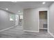 A gray-walled living room features gray wood floors and provides an entrance to the kitchen at 9763 Pine Tree Ln, Norwood, NC 28128