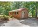 Well-maintained brick home with a metal roof, lush landscaping, and private access to the lake at 9763 Pine Tree Ln, Norwood, NC 28128