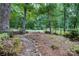 Peaceful front yard featuring a bench, lush greenery, and a serene wooded setting at 9763 Pine Tree Ln, Norwood, NC 28128