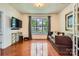Open living room with hardwood floors, large window, and modern media console at 10132 Caldwell Depot Rd, Cornelius, NC 28031