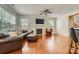 Comfortable living room featuring a fireplace, TV, hardwood floors, ceiling fan and leather sofa at 10132 Caldwell Depot Rd, Cornelius, NC 28031