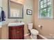Stylish powder room with wood vanity, elegant mirror, and neutral decor at 10132 Caldwell Depot Rd, Cornelius, NC 28031