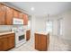 Bright kitchen showcasing an island, white appliances, and wood cabinets, open to the dining area at 104 Mooreland Ne Dr, Conover, NC 28613
