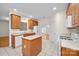 Well-lit kitchen with an island, white appliances, and wood cabinets, adjacent to dining area at 104 Mooreland Ne Dr, Conover, NC 28613