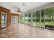 Enclosed sunroom featuring tile flooring, ceiling fan, and walls of windows with backyard views at 104 Mooreland Ne Dr, Conover, NC 28613