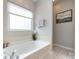 Bright bathroom features a large soaking tub, neutral paint and bright window at 1040 Stonedown Ln, Matthews, NC 28104