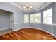 Elegant dining area with hardwood floors, a modern chandelier, and large windows at 1040 Stonedown Ln, Matthews, NC 28104