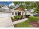 Charming home exterior showcasing a well-kept lawn, mulch flowerbeds, and inviting front entrance at 1040 Stonedown Ln, Matthews, NC 28104