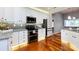 Modern kitchen features white cabinets, stainless steel appliances, granite countertops, and hardwood floors at 1040 Stonedown Ln, Matthews, NC 28104
