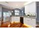 Bright kitchen with white cabinets, granite counters, stainless appliances and hardwood floors flows into living area at 1040 Stonedown Ln, Matthews, NC 28104