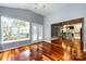 Open living room features hardwood floors, neutral paint, and bright windows with view to kitchen at 1040 Stonedown Ln, Matthews, NC 28104