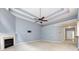 Open-concept living room featuring a fireplace, modern ceiling fan, and access to the kitchen at 1040 Stonedown Ln, Matthews, NC 28104